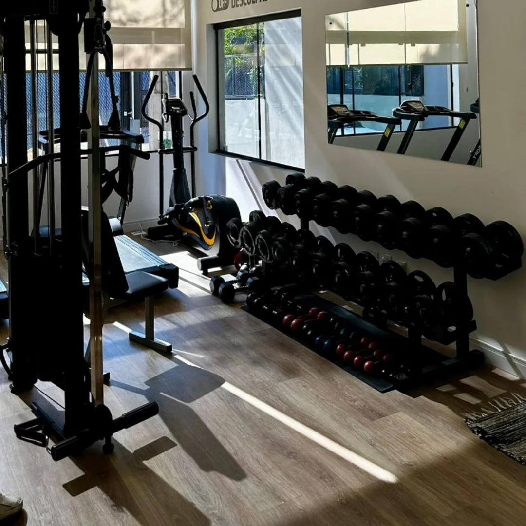 Sala de musculação com halteres, máquinas e espelhos da Bela Vida Academia